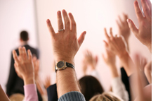 Hands raised at a business meeting
